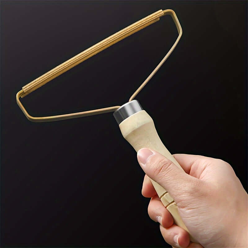 Dog hair remover grooming tool held in hand for easy pet fur and lint removal from surfaces.